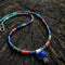 Colorful beaded lapis necklace with a square pendant on a wooden surface