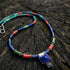 Colorful beaded lapis necklace with a square pendant on a wooden surface