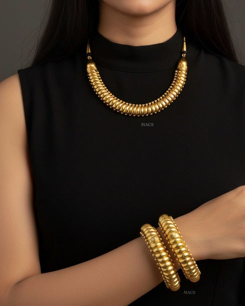 Woman wearing a gold sutlada necklace and sutlada kada bracelet. 925 pure silver shindeshahi toda bangles