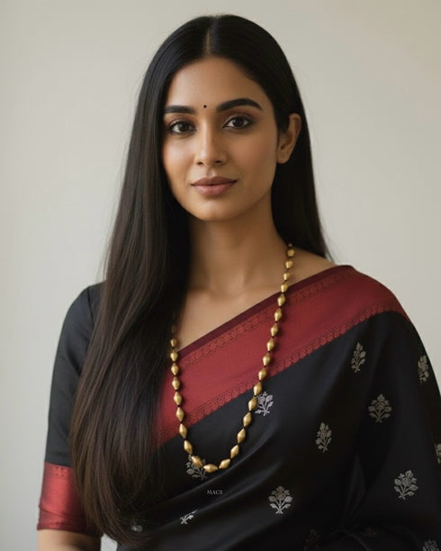 Woman wearing a black and red saree with a pure silver gold plated dholki mala